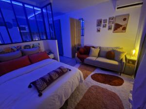 ein Schlafzimmer mit einem großen Bett und einer Couch in der Unterkunft Studio Selva in Cayenne + 26 Fotos
