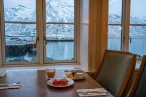 a table with two plates of food and a window with mountains at Siglo Hotel by Keahotels in Siglufjörður +68 photos