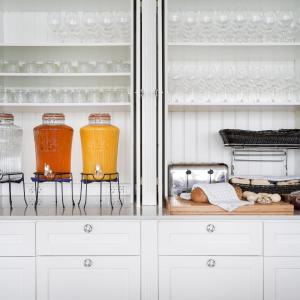 a kitchen with white cabinets and orange glass jars at Siglo Hotel by Keahotels in Siglufjörður