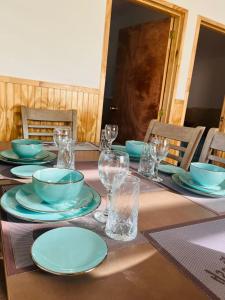 einen Tisch mit Teller, Schüsseln und Gläsern darauf in der Unterkunft Cabin for up to 7 people Natales in Puerto Natales