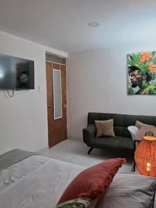 ein Wohnzimmer mit Sofa und Fernseher in der Unterkunft Habitaciones Smith in San José