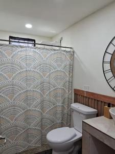 ein Badezimmer mit Toilette und Duschvorhang in der Unterkunft Habitaciones Smith in San José