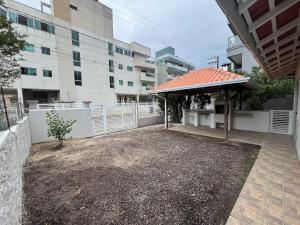 a yard with a pavilion in front of a building at Residencial Elsa Tarcila in Bombinhas