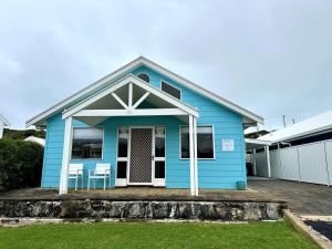 una casa azul con dos sillas delante en Dunes Aqua at Robe, en Robe