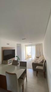 a living room with a table and a couch at Ap sol nascente in Itapema +2 photos