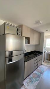 a kitchen with a stainless steel refrigerator in a room at Ap sol nascente in Itapema