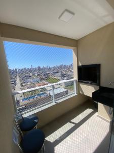 a room with a balcony with a view of a city at Ap sol nascente in Itapema
