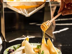 une personne versant du miel sur une assiette de nourriture dans l'établissement Hotel Mercure Roma Corso Trieste, à Rome