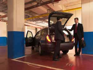 deux hommes debout à côté d'une voiture dont les portes sont ouvertes dans l'établissement Hotel Mercure Roma Corso Trieste, à Rome
