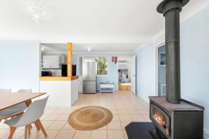 a kitchen and living room with a wood stove at Kianga Lodge, 1 Sunset Blvd in Kianga