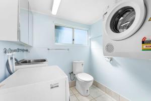 a white bathroom with a washing machine in it at Kianga Lodge, 1 Sunset Blvd in Kianga +23 photos