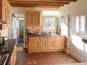 eine Küche mit Holzschränken und einer Spüle in der Unterkunft The Old Coach House in York