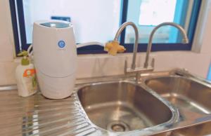 a kitchen sink with a cup next to it at V Love Homestay in Kota Samarahan +11 photos
