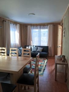 uma sala de estar com uma mesa, cadeiras e um sofá em Villa Lucita em Manquel