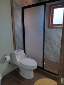 a bathroom with a white toilet and a window at Villa Lucita in Manquel +4 photos