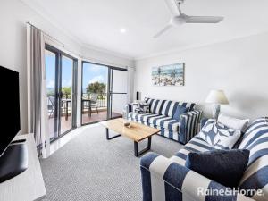 a living room with a couch and a table at Villa 7 - The Breakers Resort in Yamba