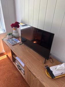 a flat screen tv sitting on top of a wooden entertainment center at Big Tiny Medlow in Medlow Bath