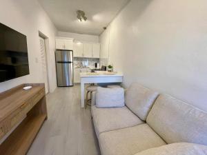 Una sala de estar con un sofá y una cocina. en Abigail's Sunlit Nook, en Isla Tórtola