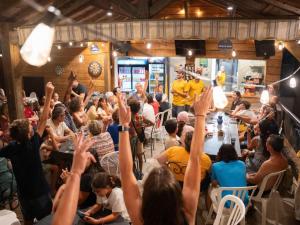 a crowd of people sitting at tables with their hands in the air at Mobil home 24m² avec terrasse à Beaumont-du-Périgord - API-1-52-412 in Beaumont-du-Périgord +28 photos