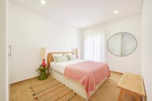ein weißes Schlafzimmer mit einem Bett und einem Spiegel in der Unterkunft Large Group Beach Stay, by TimeCooler in Setúbal