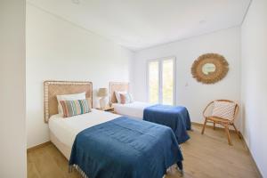 2 Betten in einem weißen Zimmer mit Spiegel in der Unterkunft Large Group Beach Stay, by TimeCooler in Setúbal