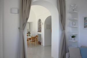 einen Flur, der zu einem Esszimmer mit einem Tisch führt in der Unterkunft La Positanella - Positano bright apartment in Positano