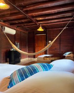 a bedroom with two beds with a rope hanging from the ceiling at Cabañas Bacali in Bacalar +10 photos