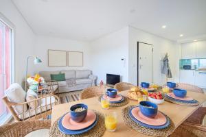 ein Esszimmer mit einem Tisch mit Essen darauf in der Unterkunft Large Group Beach Stay, by TimeCooler in Setúbal