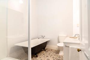 a bathroom with a bath tub and a toilet at Seaview House in Queenscliff