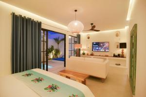 una camera da letto con un letto e un soggiorno di The Koho Air Hotel a Gili Air