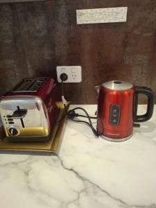 una tostadora roja sentada sobre un mostrador en Pohutukawa Studio on Hugoway, Papamoa Beach, en Papamoa 14 fotos más