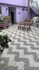 Zwei Holzbänke auf einer gefliesten Terrasse in der Unterkunft happy sigull in Arraial do Cabo