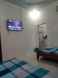 a room with a tv on the wall and a bed at Nhà nghỉ Đông Phương in Trung An +10 photos