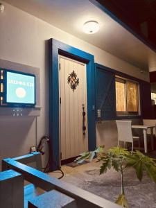 um quarto com uma porta e uma mesa com uma planta em Jazz 喫茶 Eju イージュ B&B em Urazoe