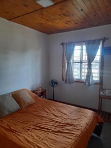 ein Schlafzimmer mit einem Bett und einem Fenster in der Unterkunft LA ARBOLADA in Mar del Plata