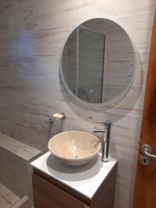 a bathroom with a bowl sink and a mirror at LA ARBOLADA in Mar del Plata +8 photos