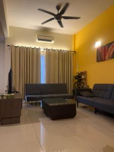 a living room with couches and a ceiling fan at Ombak Palace Bayou Lagoon Free 2 Waterpark in Melaka