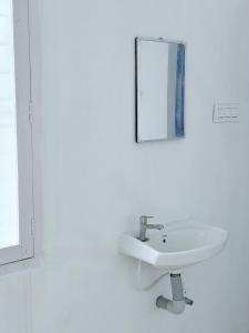 蒂鲁瓦纳马莱Annamalai Bliss Stay的一间白色浴室，配有洗手池和镜子。