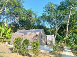 ein Zelt auf einem Feld mit Bäumen im Hintergrund in der Unterkunft Chanjao restaurant & Bar at Koh Mook in Trang