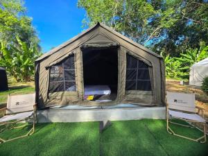 Ein Zelt mit zwei Stühlen stand auf dem Rasen. in der Unterkunft Chanjao restaurant & Bar at Koh Mook in Trang