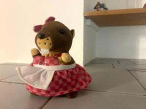 un ours en peluche vêtu d'une robe, assis par terre dans l'établissement Granny's Cosy Cottage,  46 autres photos