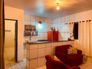 a kitchen with a red chair in a room at Casa Guiné in Goiás