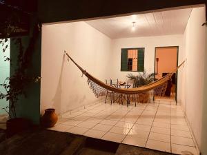 a hammock in a room with a table at Casa Guiné in Goiás