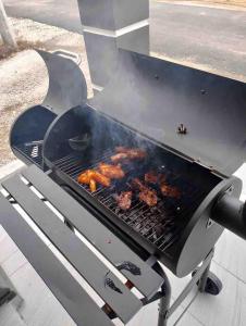 un barbecue avec de la viande qui cuit dessus dans l'établissement Hijrah De La Villa Parit Buntar Nibong Tebal Penang, à Nibung Tebal