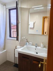 ein Badezimmer mit Waschbecken, Spiegel und Fenster in der Unterkunft Solares Style vistas al Río Miera in Solares