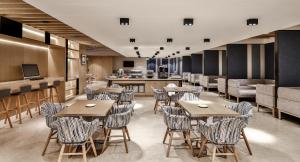 Holiday Inn Express Chengdu Wenjiang Hotspring by IHG في تشنغدو: مطعم مع طاولات وكراسي ومطبخ