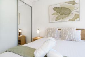 una camera da letto con un letto bianco con cuscini bianchi di Luxury Newly Furnished 2BR Apartment in Barton - Hosted by Canstay a Barton