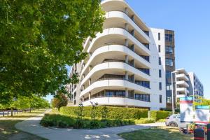 un condominio bianco con una macchina parcheggiata di fronte di Luxury Newly Furnished 2BR Apartment in Barton - Hosted by Canstay a Barton