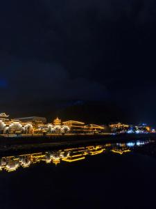 a city at night with lights in the water at GUI YUAN ZHEN PIN HOTEL,Approximately 3km away from the east gate of Zhangjiajie National Forest Park,Free Chinese western Breakfast,Free Self-Service Laundry , Attraction Tickets Serivce in advance,Free one-way shuttle service for 4 nights or more in Zhangjiajie