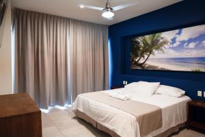 ein Schlafzimmer mit einem Bett mit einem Bild vom Strand in der Unterkunft Avenir Armonia Suites in Rincón de Guayabitos